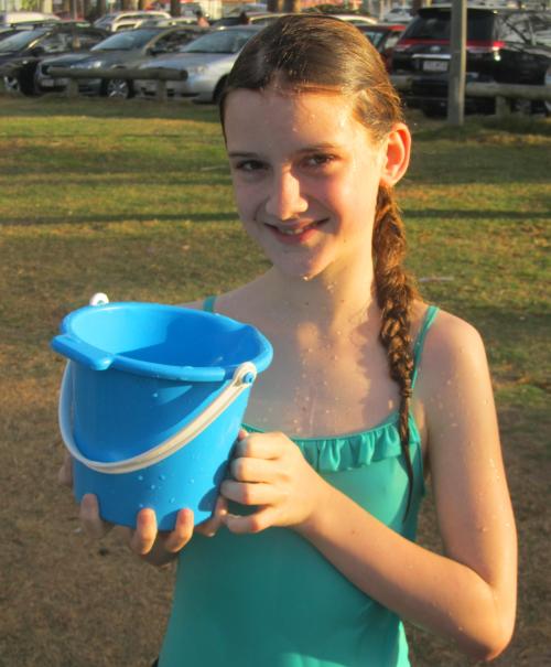 Jade looks mischievous with a bucket of water. 